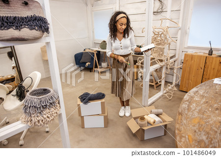 Young businessowner looking busy with packing the boxes for delivery 101486049