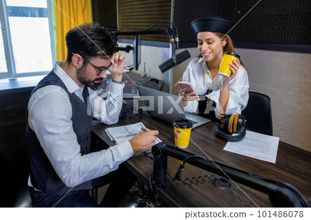 Radio dj talking to a guest in a radio studio Radio dj talking to a guest in a radio studio 101486078