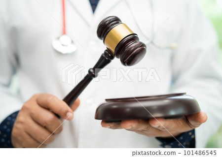 Doctor holding judge gavel, forensic medicine, medical law and crime justice concept. Doctor holding judge gavel, forensic medicine, medical law and crime justice concept. 101486545