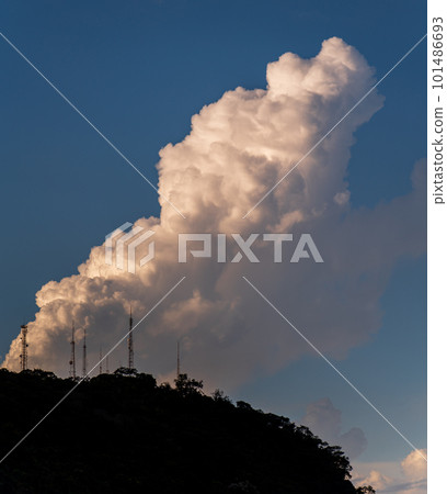 Majestic mountain silhouette under a towering cloud Majestic mountain silhouette under a towering cloud 101486693