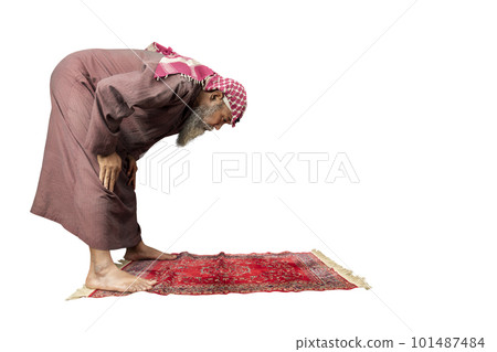 Muslim man with a beard wearing keffiyeh with agal in praying position (salat) on the prayer rug 101487484