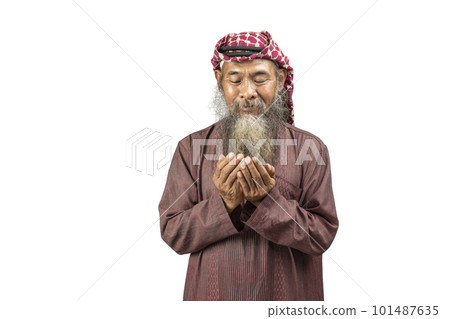 Muslim man with a beard wearing keffiyeh with agal in praying while raised hands 101487635