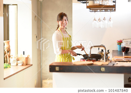 Young asian woman cooking in the kitchen Young asian woman cooking in the kitchen 101487840