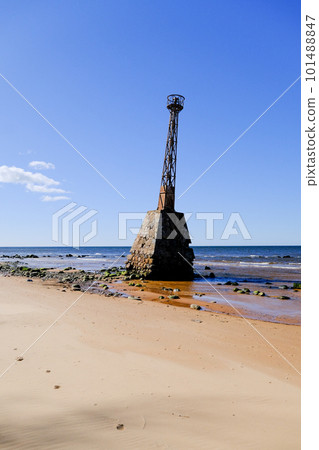 Ruins of the ancient Kurmrags lighthouse on the shore of the Gulf of Riga. Stone masonry in the lower part of the lighthouse, above which is the metal body of the lighthouse made in Sweden. Baltic Sea Ruins of the ancient Kurmrags lighthouse on the shore of the Gulf of Riga. Stone masonry in the lower part of the lighthouse, above which is the metal body of the lighthouse made in Sweden. Baltic Sea 101488847