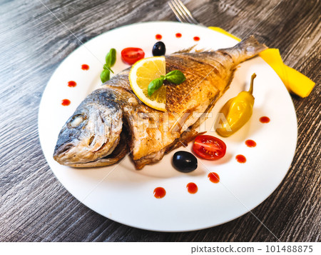Golden fried sea bream fish on plate with vegetables, top view. High quality photo Golden fried sea bream fish on plate with vegetables, top view. High quality photo 101488875