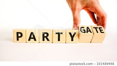 Party and partygate symbol. Concept words Party and Partygate on wooden cubes. Businessman hand. Beautiful white table white background. Business party and partygate concept. Copy space. Party and partygate symbol. Concept words Party and Partygate on wooden cubes. Businessman hand. Beautiful white table white background. Business party and partygate concept. Copy space. 101489498