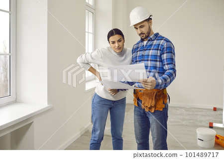 Builder foreman and young woman looking at new house or apartment renovation plan Builder foreman and young woman looking at new house or apartment renovation plan 101489717