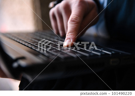 Men's hand typing on a laptop keyboard. Selective focus 101490220