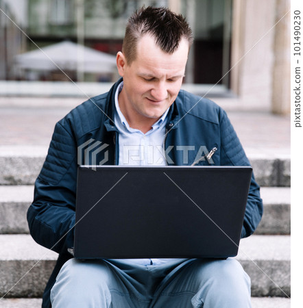A confident business person with a laptop in the city. Business vision, communications, online shopping A confident business person with a laptop in the city. Business vision, communications, online shopping 101490230