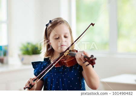 Child playing violin. Remote learning. Child playing violin. Remote learning. 101490482