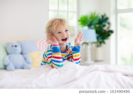 Child playing in bed. Kids room. Baby boy at home. 101490490