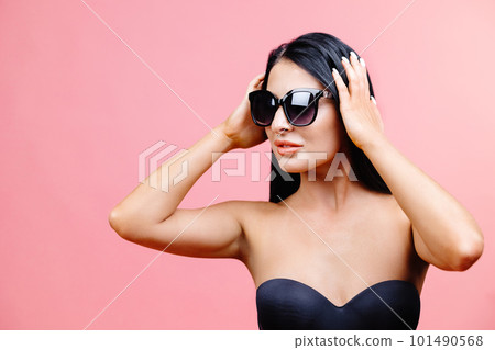 Sexy woman in black swimsuit with sunglasses isolated on pink background in studio. 101490568