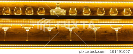 Glasses of wine. Glasses hanging above the bar in restaurant. Empty glasses for wine. Wine and martini glasses in shelf above bar rack in restaurant. night life Glasses of wine. Glasses hanging above the bar in restaurant. Empty glasses for wine. Wine and martini glasses in shelf above bar rack in restaurant. night life 101491007
