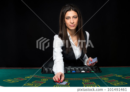 The beautiful girl, dealer, behind a table for poker The beautiful girl, dealer, behind a table for poker 101491461