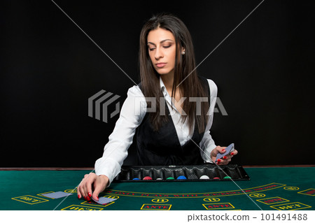 The beautiful girl, dealer, behind a table for poker 101491488