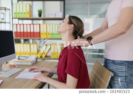 Colleague massages neck of tired woman with strong hands 101491523