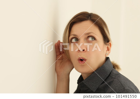Curious woman listens to discussion of colleagues in office 101491550