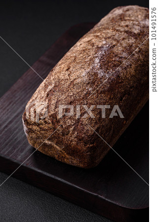 Loaf of fresh crispy brown bread with grains and seeds Loaf of fresh crispy brown bread with grains and seeds 101491576
