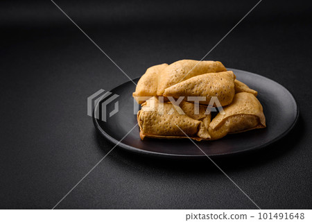 Delicious pancakes triangular shape with meat, salt and spices Delicious pancakes triangular shape with meat, salt and spices 101491648