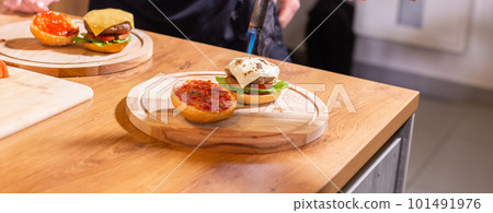 Banner Preparing delicious burgers. Chef cooking meat burgers with beef, cheese and vegetables. Close-up copy space Banner Preparing delicious burgers. Chef cooking meat burgers with beef, cheese and vegetables. Close-up copy space 101491976