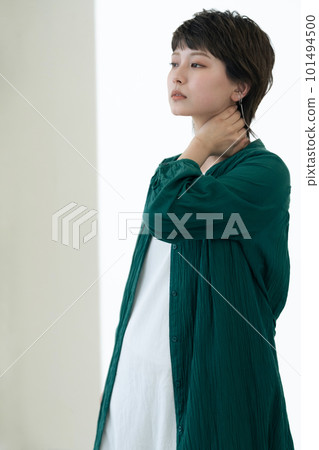 A young woman standing by the window 101494500