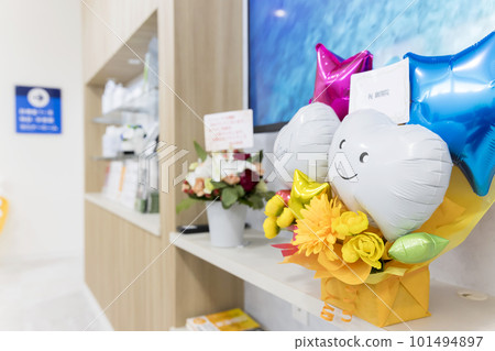 An image of a dentist opening a balloon gift placed in the waiting room 101494897