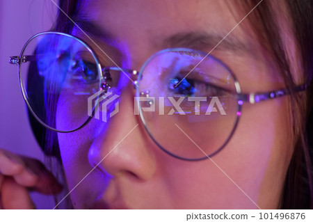 Female gamer wearing glasses for reducing eye strain blurred vision at home 101496876
