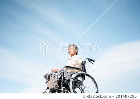 Senior man riding a wheelchair with the blue sky in the background 101497296