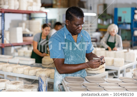 Man potter processing new crafted plates Man potter processing new crafted plates 101498150