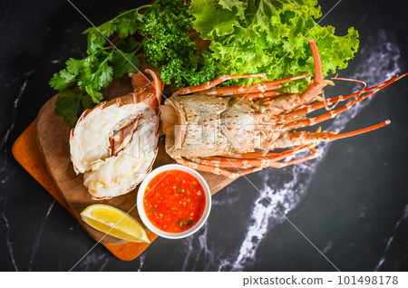 spiny lobster food on plate, fresh lobster or rock lobster seafood with herb and spices lemon coriander parsley lettuce salad, lobster for cooking food and seafood sauce 101498178