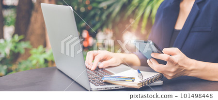 Woman using phone and laptop to search internet. 101498448