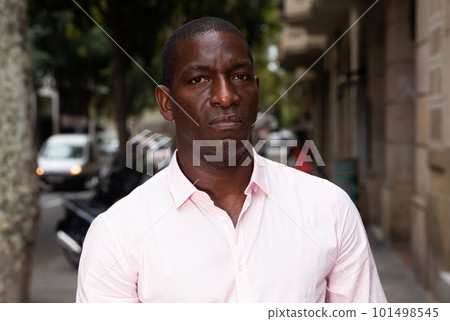 Focused man walking along city street 101498545
