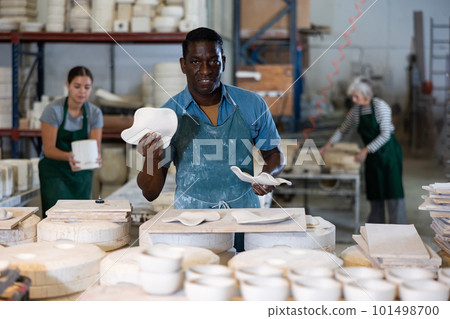African american artisan having ceramics in hands and standing in workshop African american artisan having ceramics in hands and standing in workshop 101498700