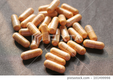 top view of herbal medicine capsule dropping on table  101499998