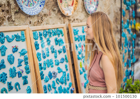 Closeup of beautiful woman looking at Turkish souvenirs for sale in the Grand Bazaar Istanbul, Turkey Closeup of beautiful woman looking at Turkish souvenirs for sale in the Grand Bazaar Istanbul, Turkey 101500130