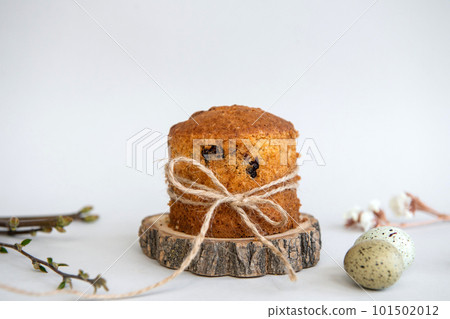 Easter baking. Quail eggs lie near the Easter cake with a ribbon on a wooden stand. Raisin Pie Easter baking. Quail eggs lie near the Easter cake with a ribbon on a wooden stand. Raisin Pie 101502012