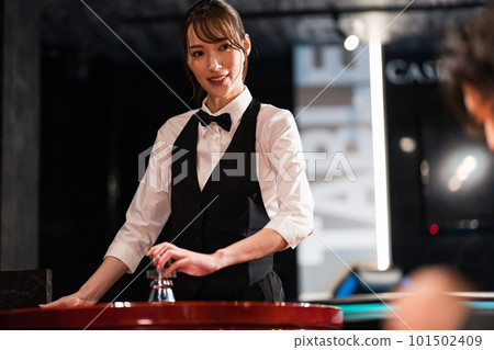 Female dealer and male customer in casino Female dealer and male customer in casino 101502409