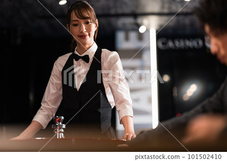 Female dealer and male customer in casino 101502410