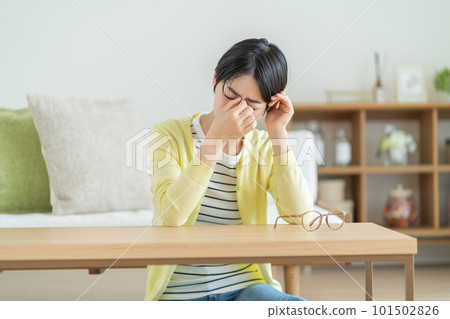 Woman with tired eyes, woman suffering from eye strain, woman suffering from migraine, woman suffering from anxiety, woman thinking about something 101502826