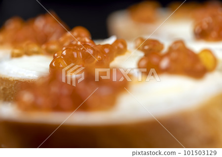 Thinly sliced baguette with salmon caviar and butter Thinly sliced baguette with salmon caviar and butter 101503129