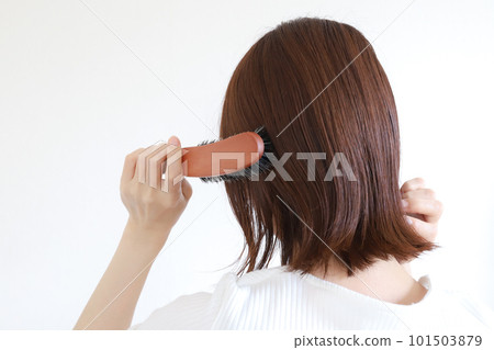 A woman who brushes hair with a brush A woman who brushes hair with a brush 101503879