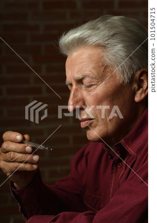 Portrait of sad sick old man with thermometer Portrait of sad sick old man with thermometer 101504715