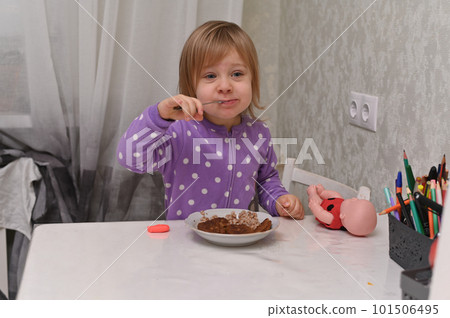 a spoon in a little girl's mouth. she eats, and it's very tasty for her. 101506495