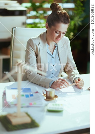 business owner woman in light business suit in green office 101506958