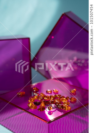 Amber ring and stones on pink glass podium and blue sunlit background. Modern gemstone presentation. November birthstone Amber ring and stones on pink glass podium and blue sunlit background. Modern gemstone presentation. November birthstone 101507454