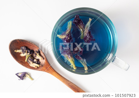 Chinese blue anchan tea in a glass cup and wooden spoon on a white 101507923