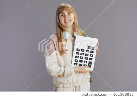 smiling modern young woman in beige tracksuit with calculator smiling modern young woman in beige tracksuit with calculator 101508032