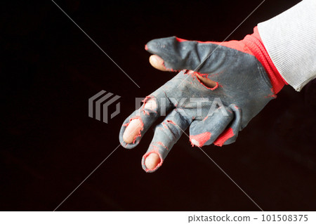 Demaged glove. Defocus worn dirty and leaky gloves. One male hand in worn workers gloves, protection against damage during operation, closeup on background. Out of focus 101508375