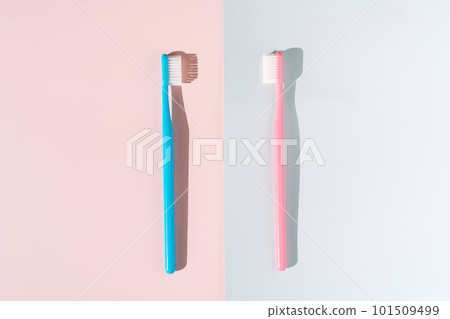 Blue and pink toothbrush on pink and blue background under hard light Blue and pink toothbrush on pink and blue background under hard light 101509499