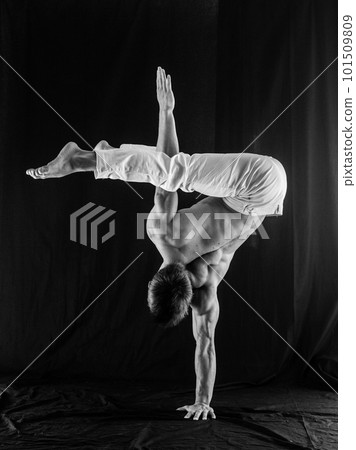 circus artist keeps balance on one hand isolated on a black background. Concept of individuality, creativity and self-confidence 101509809